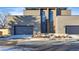 Modern home exterior with a brick facade, wooden accents, two garage doors, and manicured landscaping at 16133 W 14Th Ave, Golden, CO 80401