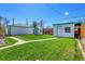 Spacious backyard with well-maintained lawn and white sheds or storage buildings at 891 Ursula St, Aurora, CO 80011