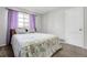 Bright bedroom with neutral walls, plush gray carpet, and a large window dressed with vibrant violet curtains at 891 Ursula St, Aurora, CO 80011