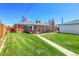 Charming brick home with a well-manicured lawn and a walkway leading to the entrance at 891 Ursula St, Aurora, CO 80011