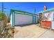 Detached white garage with a teal trim and a large door for vehicle storage at 891 Ursula St, Aurora, CO 80011