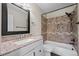 Stylish bathroom features granite countertop vanity and a shower and tub combo with decorative tile at 848 Mockingbird Ln, Brighton, CO 80601