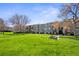 Gray apartment building with balconies, patios, lawn, and mature trees on a sunny day at 16359 W 10Th Ave # X6, Golden, CO 80401