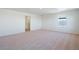 Spacious bedroom featuring neutral carpet, a window, and a doorway leading to another room at 13489 Valentia Pl, Thornton, CO 80602