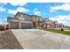 Exterior view of homes with long driveways, landscaped front yards, and attached two-car garages at 13489 Valentia Pl, Thornton, CO 80602