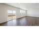 Bright and spacious room featuring hardwood floors, white walls, and natural light from sliding glass doors at 13489 Valentia Pl, Thornton, CO 80602