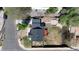 An aerial view reveals a home with a dark roof, small backyard, and a quaint patio area, surrounded by verdant trees at 2441 W 55Th Ave, Denver, CO 80221