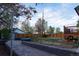 Backyard with a paver patio and wooden deck beyond a grass yard at 2441 W 55Th Ave, Denver, CO 80221