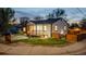 Charming single-Gathering home with a cozy front porch and manicured lawn, illuminated by warm exterior lighting at dusk at 2441 W 55Th Ave, Denver, CO 80221