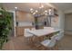 Bright kitchen features a modern chandelier, stainless steel appliances, and an island with white marble countertop at 2441 W 55Th Ave, Denver, CO 80221
