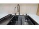 Close-up of the sleek black modern sink with a single handle faucet, and designer counter tops at 2441 W 55Th Ave, Denver, CO 80221