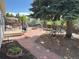 The backyard features a brick patio, an outdoor kitchen and bar, mature trees, and wood fencing at 4383 S Eagle Cir, Aurora, CO 80015