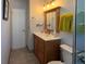 Bright bathroom with wood vanity, medicine cabinet and standard toilet at 4383 S Eagle Cir, Aurora, CO 80015