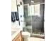 Updated bathroom featuring a glass door shower with rock flooring, updated tile, and a wooden cabinet at 4383 S Eagle Cir, Aurora, CO 80015