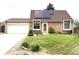 The brick home has a well manicured front yard with a lush green lawn and solar panels at 4383 S Eagle Cir, Aurora, CO 80015