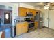 Well-equipped kitchen with stainless steel appliances, tile floor, and wooden cabinets at 4383 S Eagle Cir, Aurora, CO 80015