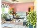Cozy living room featuring a sofa, chairs, plants, light-colored carpet, and pink walls at 4383 S Eagle Cir, Aurora, CO 80015