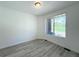 Well-lit bedroom with gray wood floors and a window overlooking the yard at 9662 Browns Peak Cir, Littleton, CO 80125