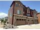 Modern townhome showcases a two-car garage with stone and siding exterior, perfect for community living at 9662 Browns Peak Cir, Littleton, CO 80125