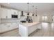 Open kitchen with stainless steel appliances, granite countertops, island, and white cabinets at 9662 Browns Peak Cir, Littleton, CO 80125