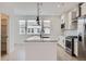 Bright kitchen with white cabinets, granite countertops, island and stainless steel appliances at 9662 Browns Peak Cir, Littleton, CO 80125
