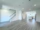 Open concept living room featuring light gray wood floors and an adjacent staircase at 9662 Browns Peak Cir, Littleton, CO 80125