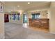 Finished basement featuring a bar area with stone accents, stools and bright windows at 2485 Greensborough Cir, Highlands Ranch, CO 80129