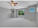 Bright bedroom with neutral carpet, three windows, and a ceiling fan at 2485 Greensborough Cir, Highlands Ranch, CO 80129