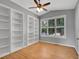 Cozy bedroom featuring built-in bookshelves, hardwood floors, and a ceiling fan at 2485 Greensborough Cir, Highlands Ranch, CO 80129
