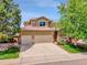 Charming two-story home featuring a large driveway and a well-maintained front yard with mature trees at 2485 Greensborough Cir, Highlands Ranch, CO 80129