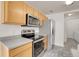 Modern kitchen with stainless steel appliances and light wood cabinets at 7440 S Blackhawk St # 101, Englewood, CO 80112