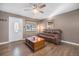 Cozy living room features a large window, ceiling fan, and an oversized leather couch at 9450 Lillian Ln, Thornton, CO 80229