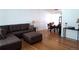 Open concept living room and dining area with beautiful hardwood floors and a comfortable brown leather sectional sofa at 2580 Valley View Dr, Denver, CO 80221