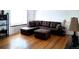 Spacious living room featuring a comfortable brown leather sectional sofa, hardwood floors, and a cozy window seat at 2580 Valley View Dr, Denver, CO 80221