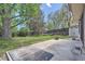Large backyard with mature trees, a grassy area, and a concrete patio perfect for outdoor activities at 8144 W 81St Dr, Arvada, CO 80005
