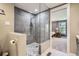 Modern bathroom featuring a stylish glass-enclosed shower with gray tiles and a mosaic floor design at 8144 W 81St Dr, Arvada, CO 80005