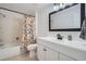 Bright bathroom features a white vanity, floral shower curtain, and modern fixtures at 8144 W 81St Dr, Arvada, CO 80005