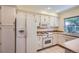 Modern kitchen featuring white cabinets, tile flooring, and stainless steel appliances at 8144 W 81St Dr, Arvada, CO 80005