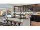 The kitchen features dark cabinets, stainless steel appliances, sleek backsplash and an expansive granite island at 21901 E 42Nd Pl, Aurora, CO 80019