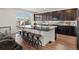 Stylish kitchen island features dark granite countertops, seating, stainless steel sink, and dark cabinetry at 21901 E 42Nd Pl, Aurora, CO 80019