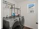 A clean laundry room features modern washer and dryer set with wire shelving at 21901 E 42Nd Pl, Aurora, CO 80019