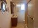 Bathroom with wood vanity, mirror, sconces, and a shower with sliding glass doors at 10885 Mildred Dr, Northglenn, CO 80233