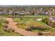 Expansive aerial view showcasing a serene community with parks, walking paths, and homes at 12704 Leyden St # D, Thornton, CO 80602