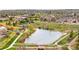 Picturesque aerial view of the community featuring a pond, walking trails, and lush green spaces at 12704 Leyden St # D, Thornton, CO 80602