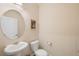 Powder bathroom featuring a pedestal sink with round mirror, and a toilet with a light wall color at 12704 Leyden St # D, Thornton, CO 80602