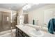 Bathroom featuring double sinks and a tiled walk-in shower at 12704 Leyden St # D, Thornton, CO 80602