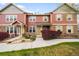 Two story home with yellow shutters and brick accents with landscaped yard on a sunny day at 12704 Leyden St # D, Thornton, CO 80602