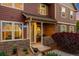 Cozy townhome entrance with stone accents, charming shrubs, and covered porch area for relaxing at 12704 Leyden St # D, Thornton, CO 80602