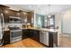 Well-equipped kitchen with stainless steel appliances, dark cabinetry, and hardwood floors at 12704 Leyden St # D, Thornton, CO 80602