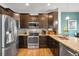 Modern kitchen features stainless steel appliances, dark wood cabinets, and granite countertops at 12704 Leyden St # D, Thornton, CO 80602